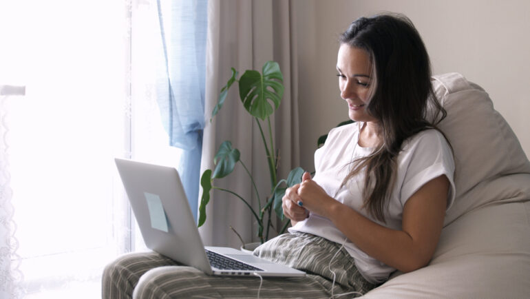 Young woman wears headset conference calling on laptop talks with online teacher studying, working from home. Lady student learning using computer webcam chat makes notes. Distance education concept Young woman wears headset conference calling on laptop talks with online teacher studying, working from home. Lady student e learning using computer webcam chat makes notes. Distance education concept